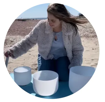 Woman on beach with bowls.