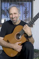 Head & shoulders of Dave Giardina holding guitar