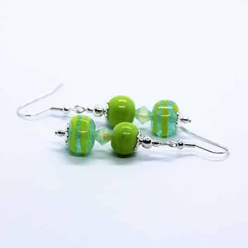 Pair of earrings featuring green beads on silver wire.